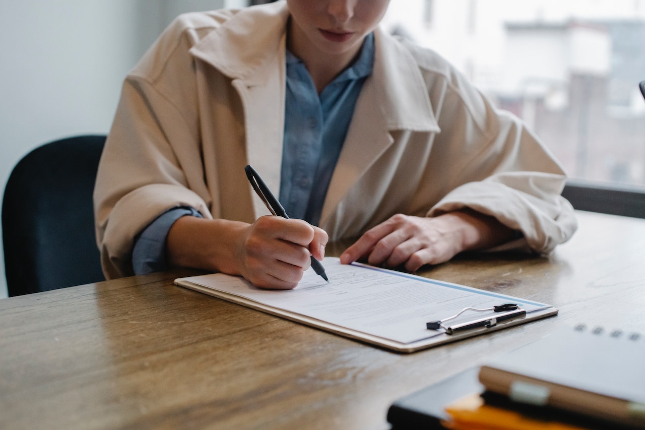 a woman filling out an application for PCO Licence