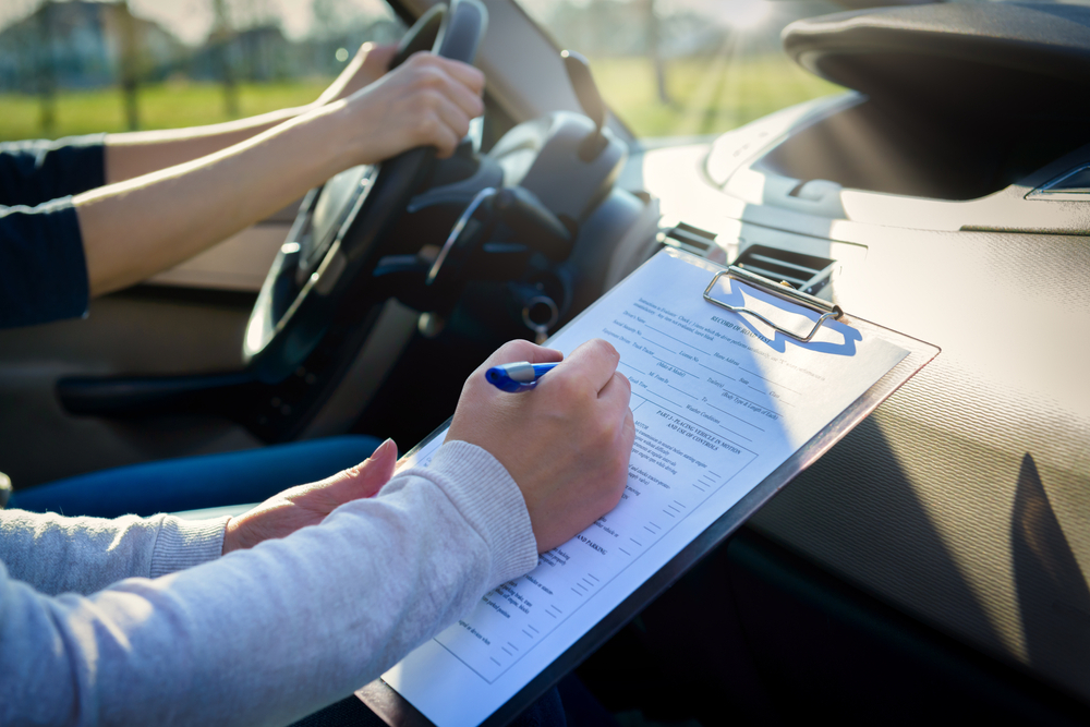 a driving instructor with a checklist examining the driver for Pco Licence Renewal